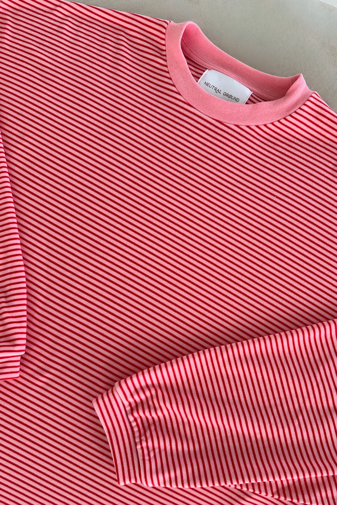 Close-up of a pink striped shirt with a visible brand label.