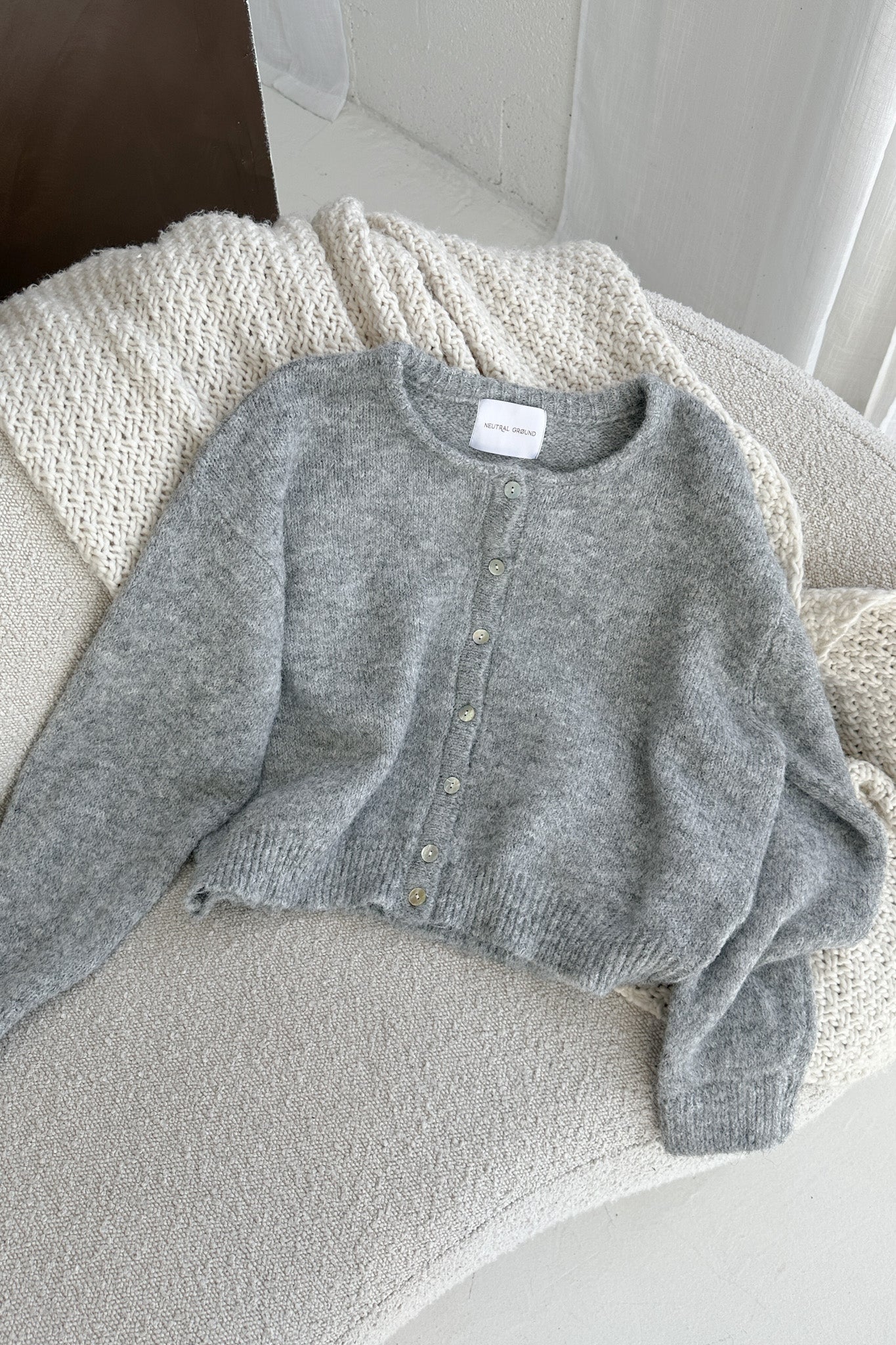Gray sweater on a textured surface with a blurred background
