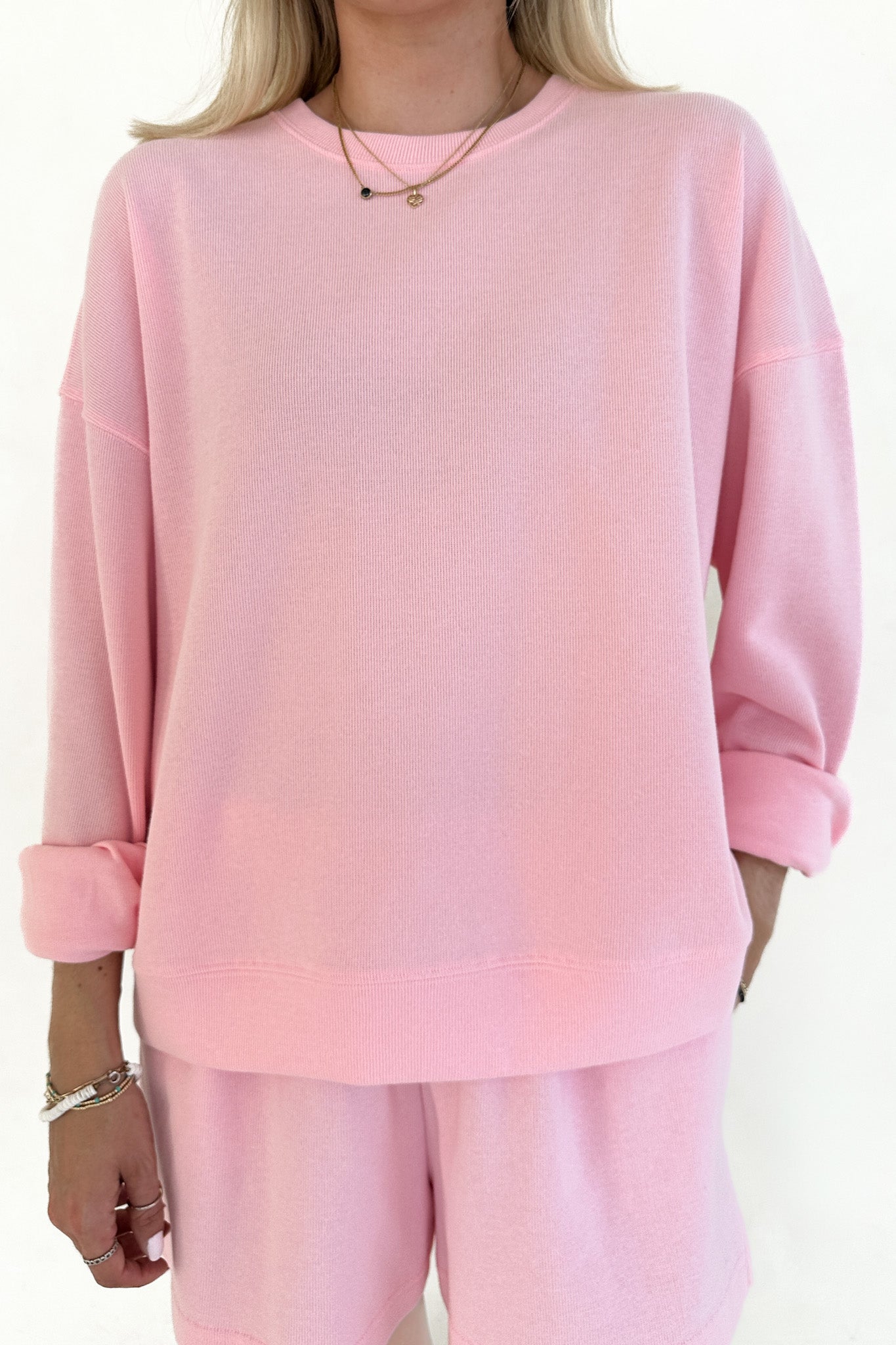 Person wearing a pink outfit with a plain background