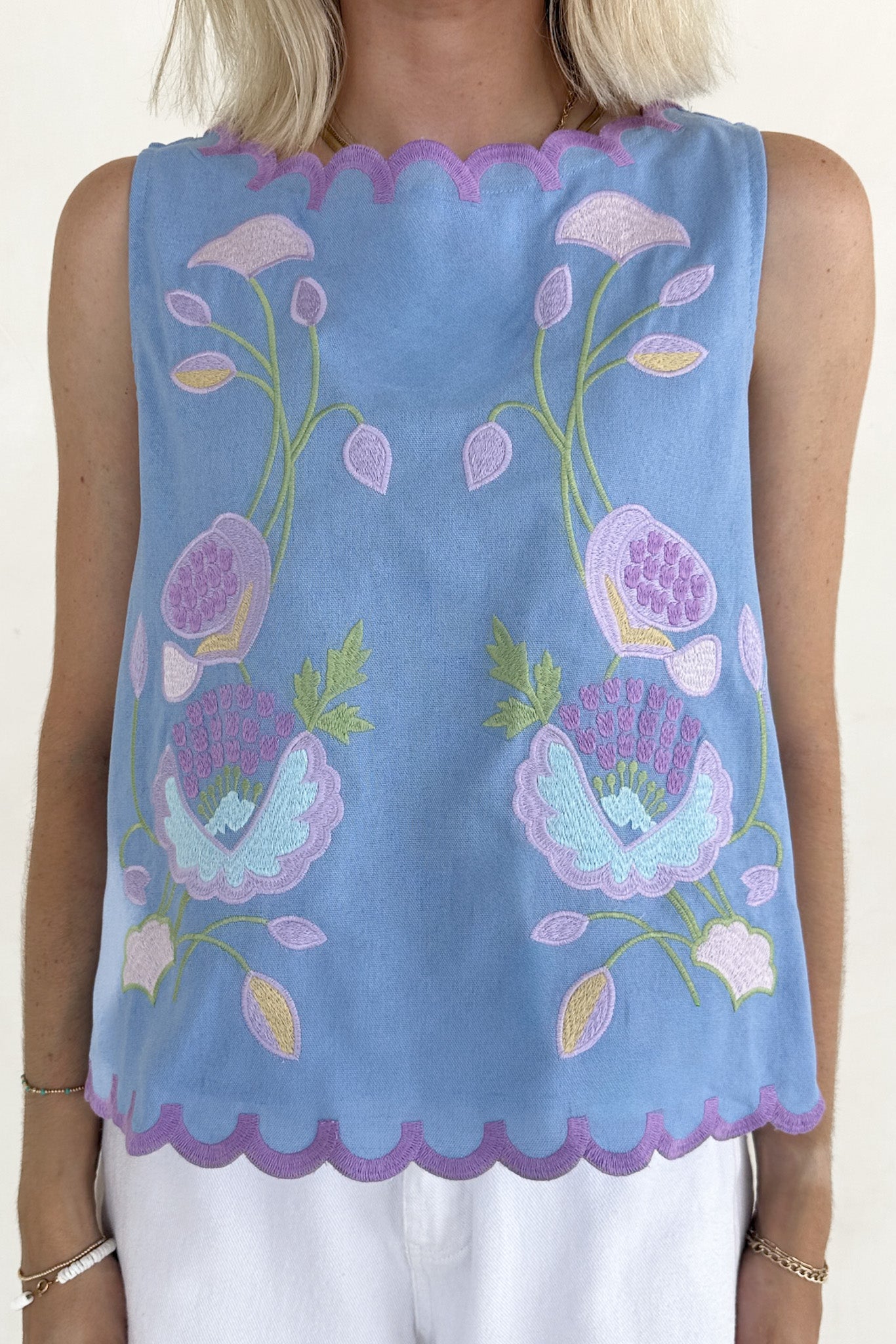 Light blue sleeveless top with floral embroidery on a plain background
