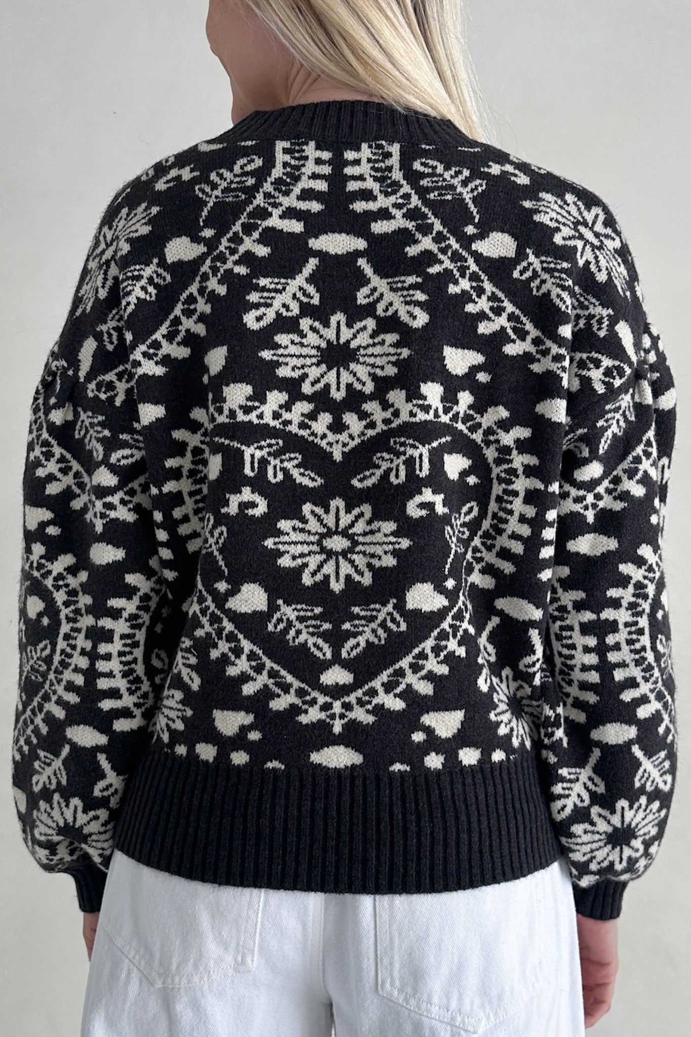 Person wearing a black sweater with white pattern