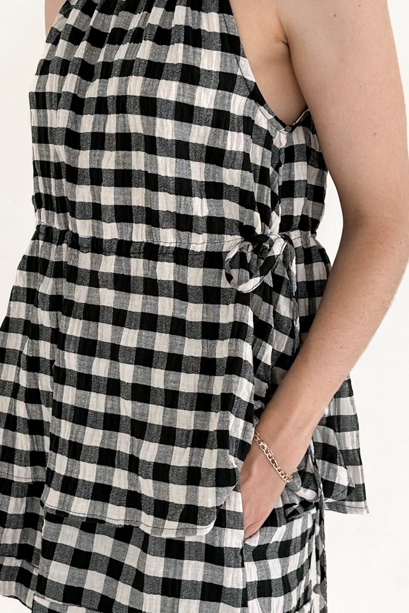 Black and white checkered dress with a tie detail on a white background