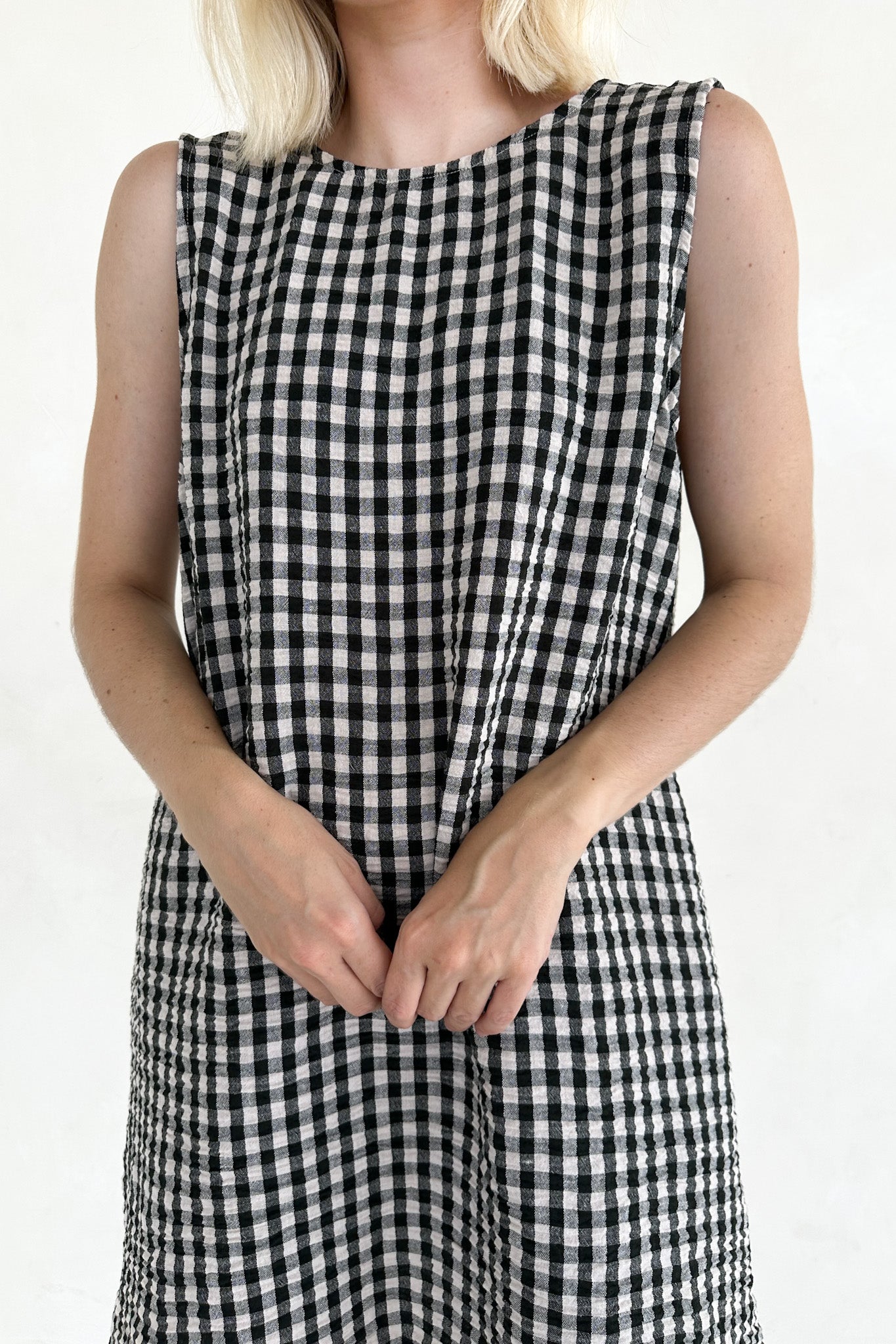 Person wearing a black and white checkered dress on a white background
