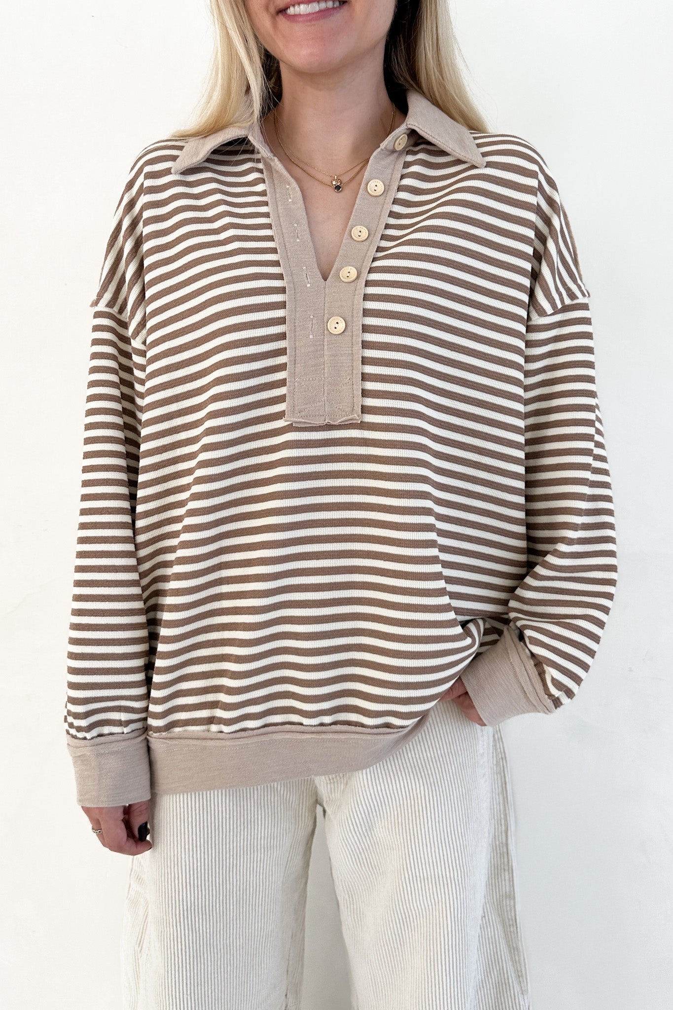 Woman wearing a striped shirt with a plain background