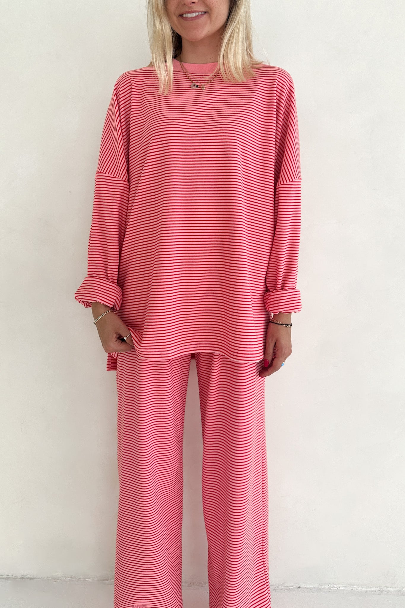 Woman wearing a pink and white striped outfit against a white background