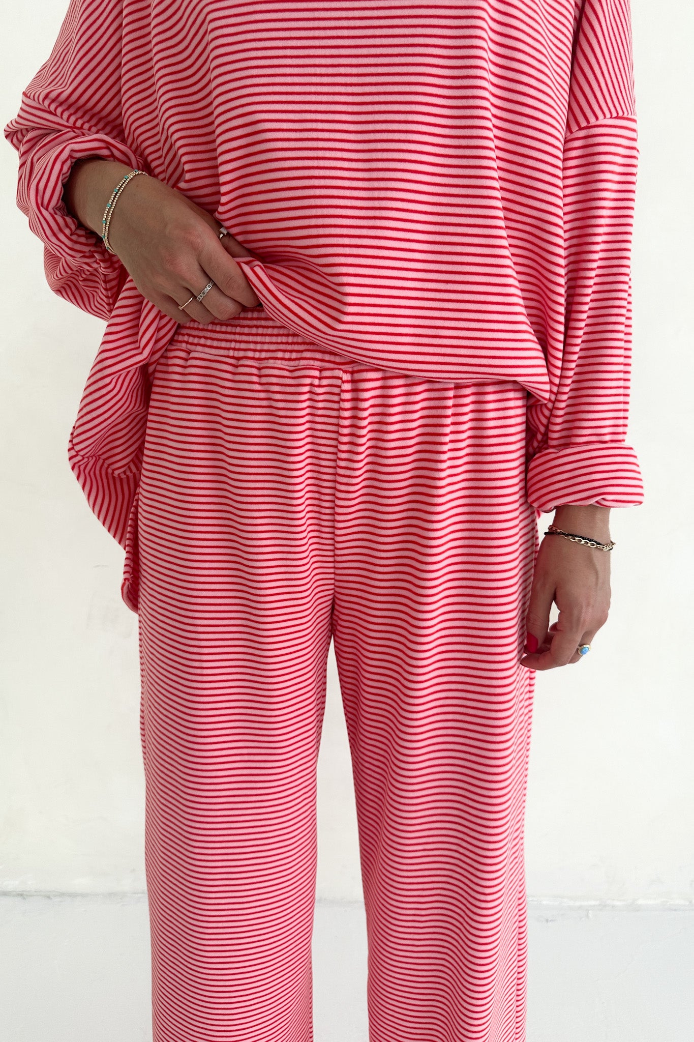 Pink striped outfit with long-sleeve top and pants on a white background
