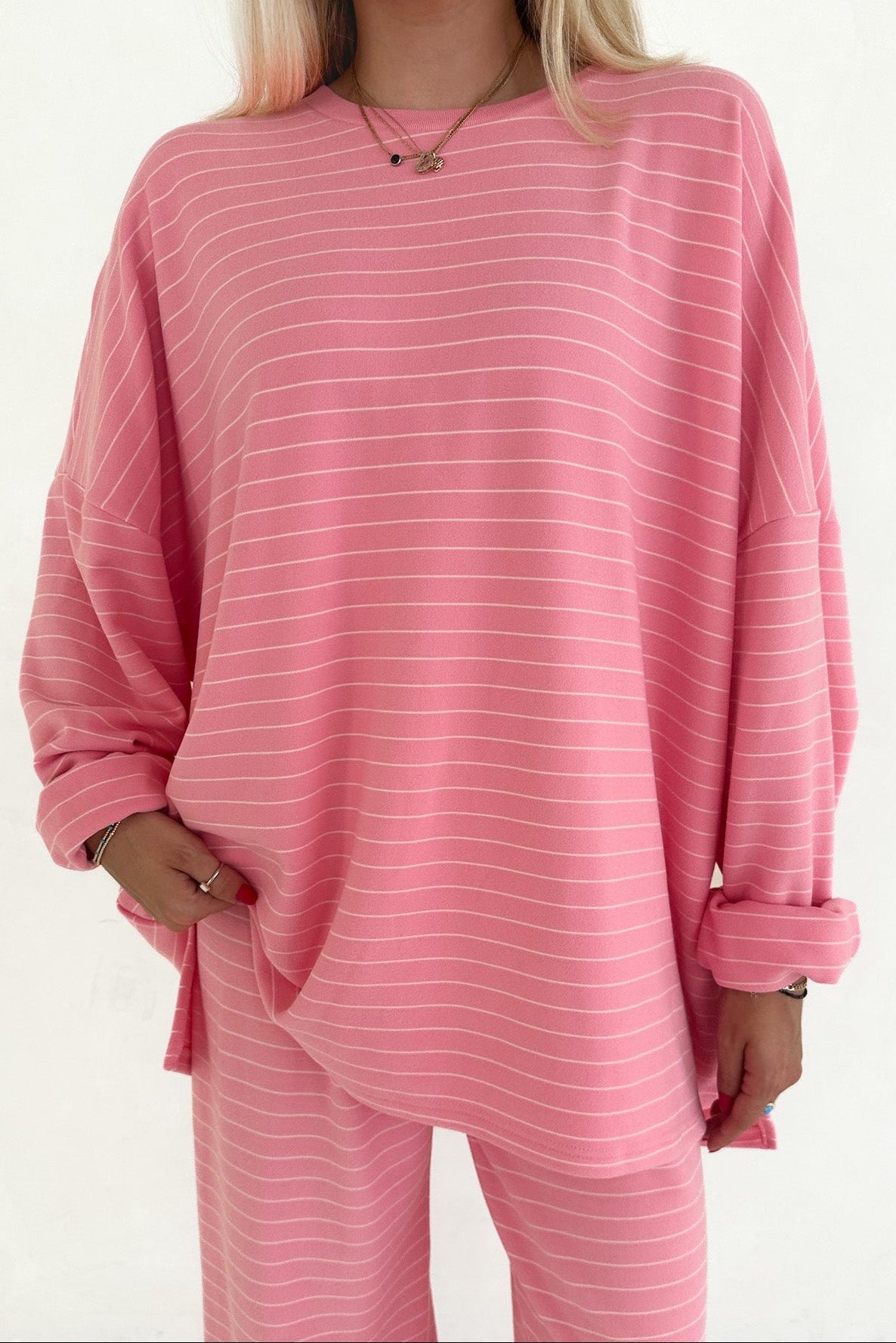 Person wearing a pink striped outfit on a white background