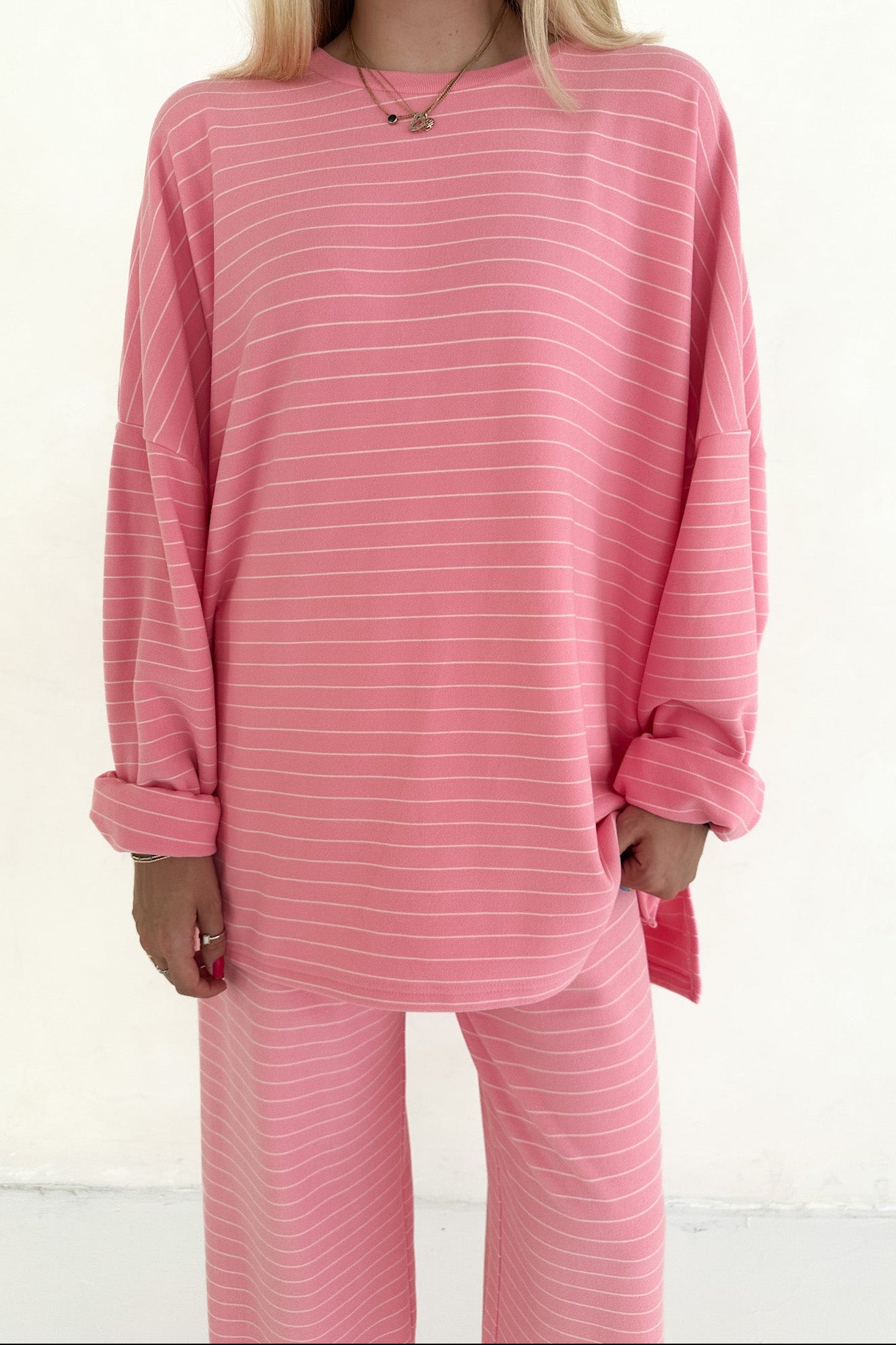 Person wearing pink striped pajamas on a white background