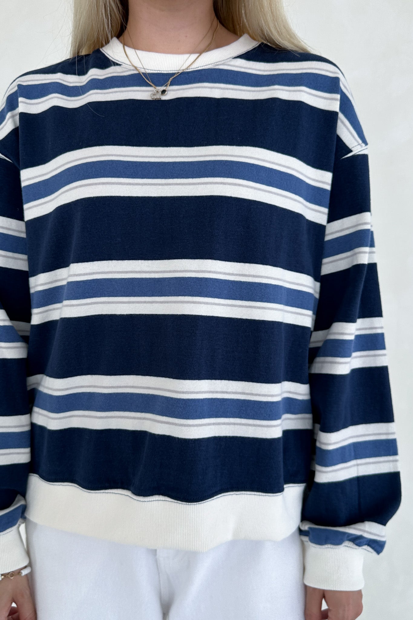 Navy and white striped sweater worn by a person on a white background