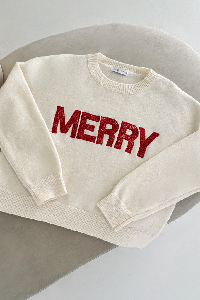 Beige sweater with red 'MERRY' text on a light background