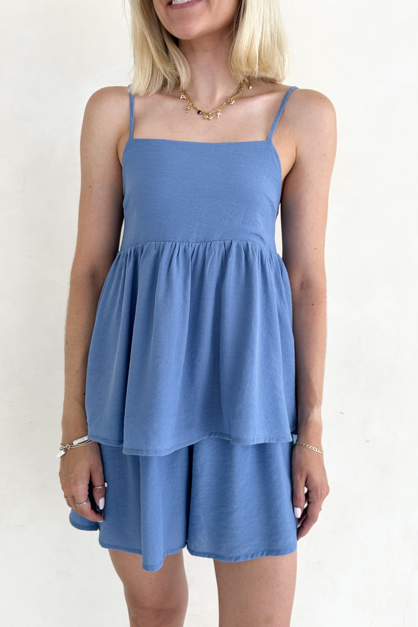 Woman wearing a blue dress with a plain background