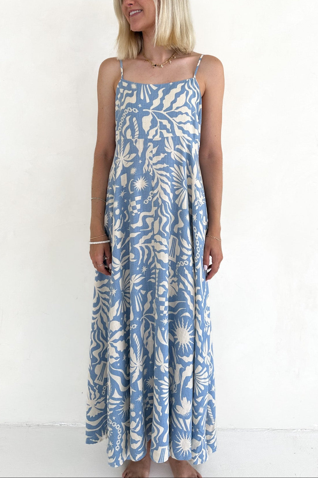 Woman wearing a blue floral dress against a white background