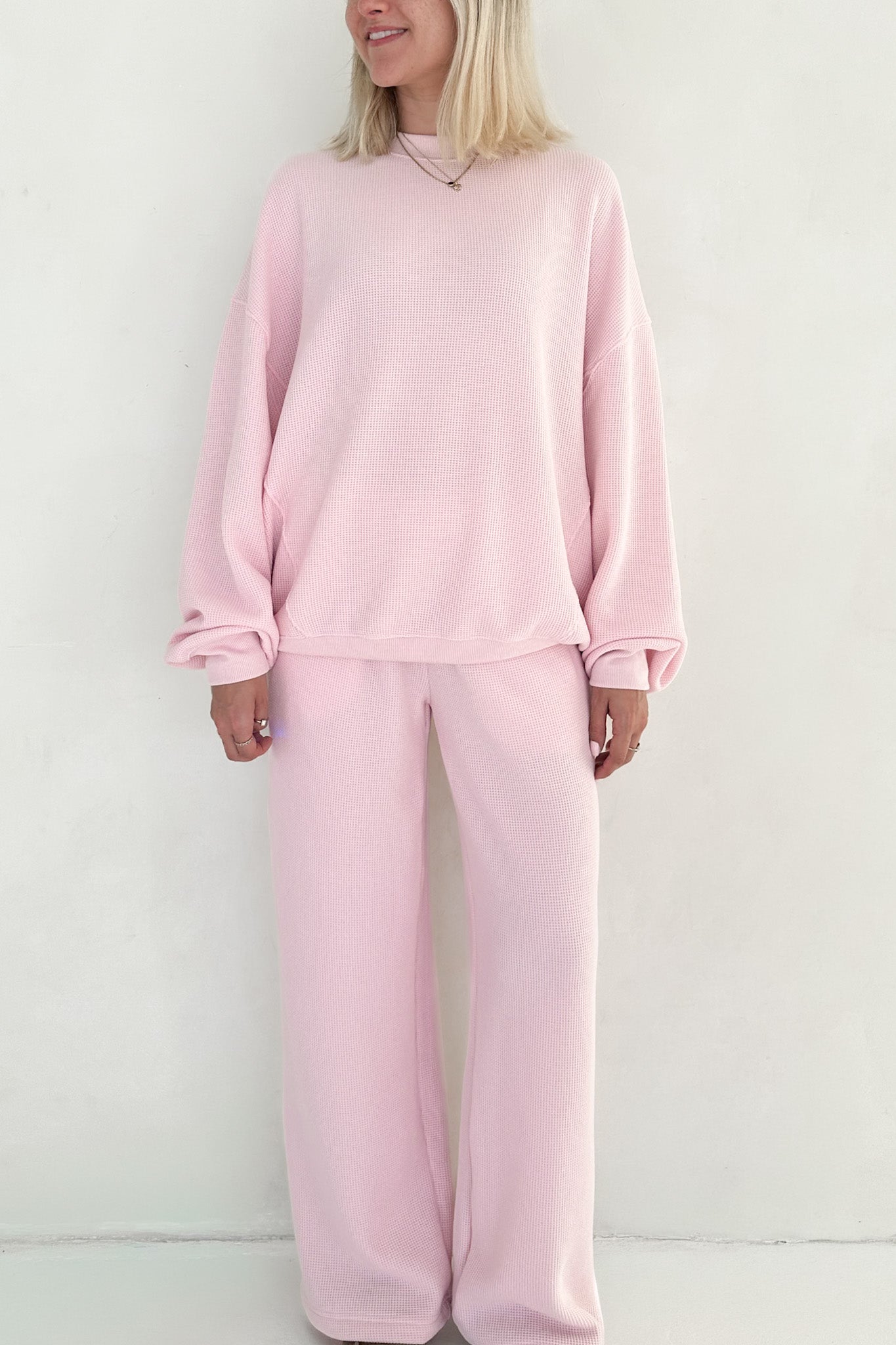 Person wearing a pink pajama set against a white background