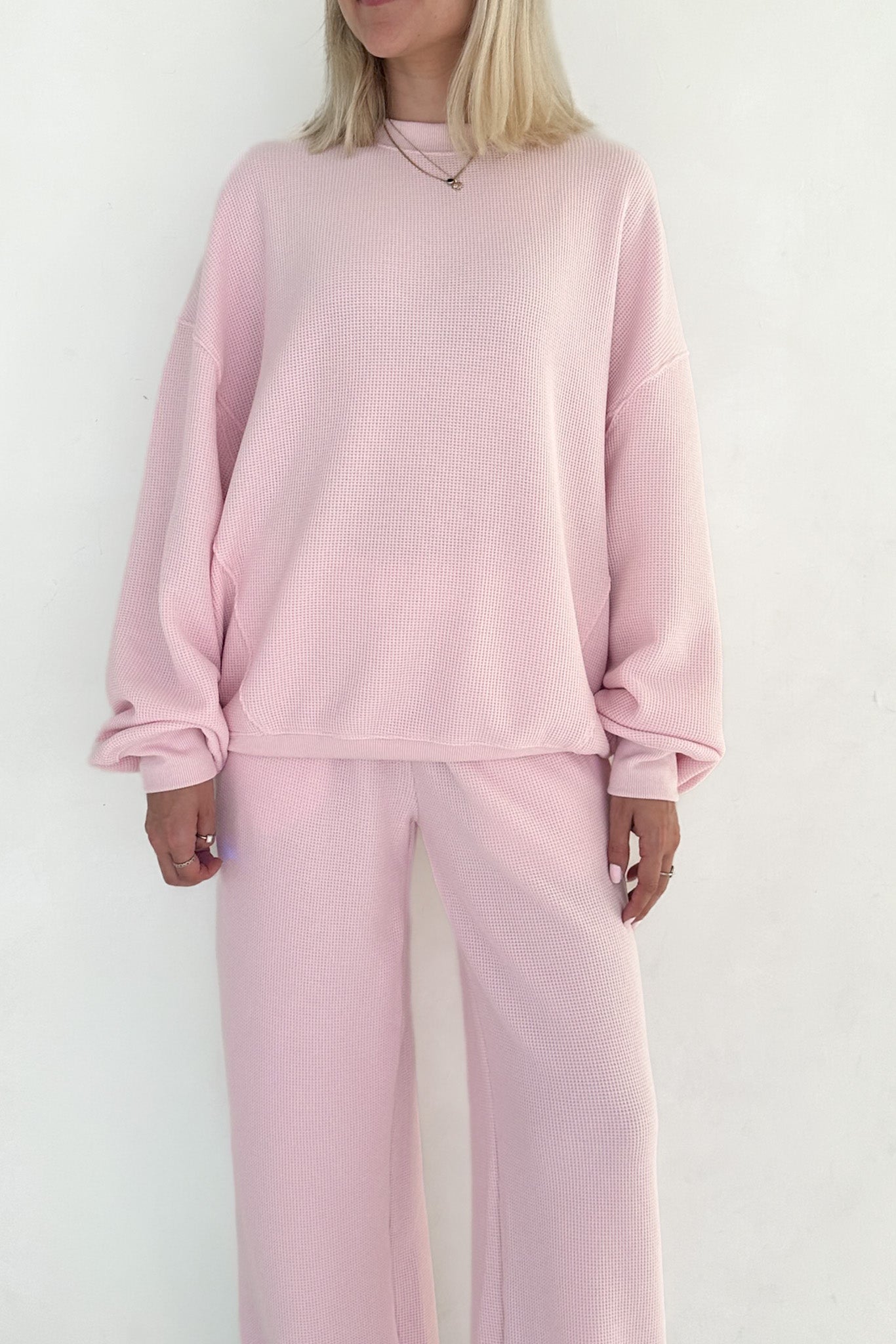 Person wearing a pink outfit against a white background