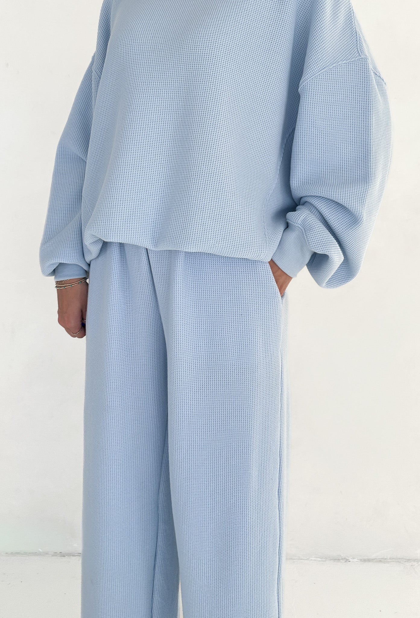 Light blue textured outfit with a top and pants on a white background