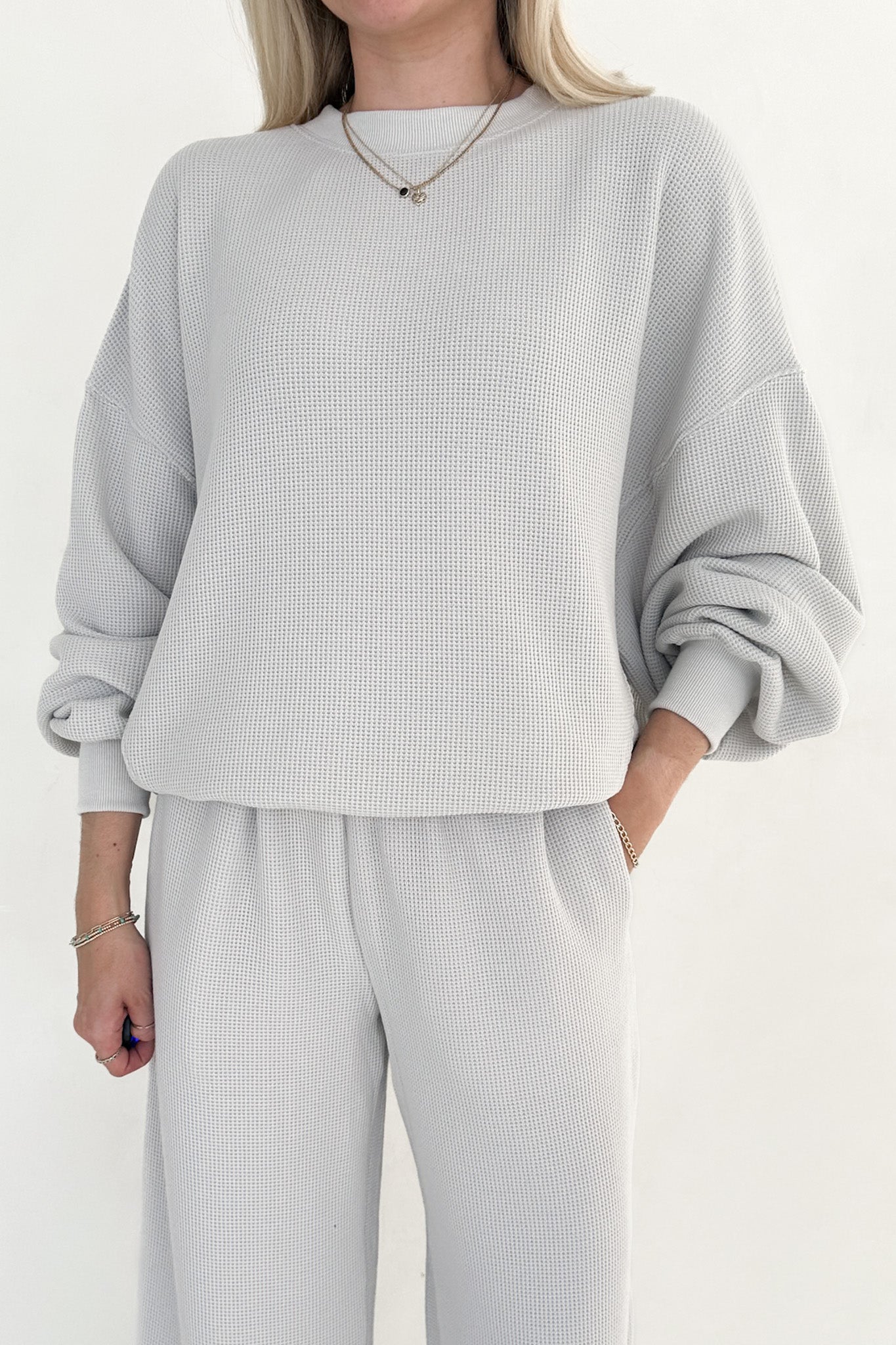 Person wearing a light gray waffle knit outfit on a white background