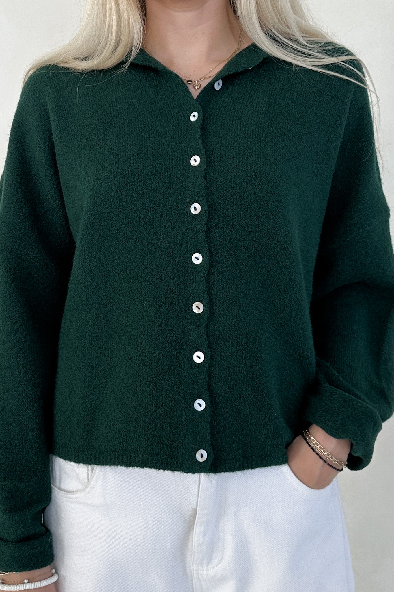 Green button-up shirt worn by a person with a neutral background