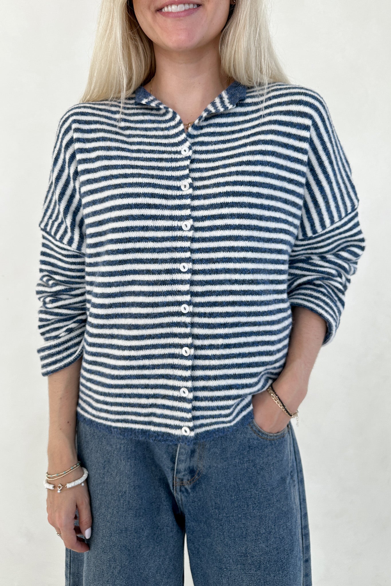 Person wearing a blue and white striped shirt with a plain background
