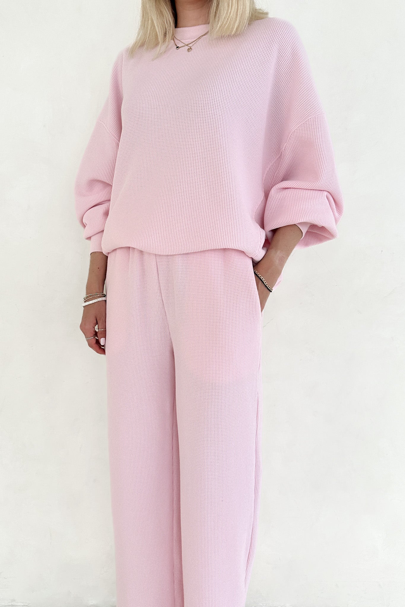 Person wearing a pink outfit with a plain white background