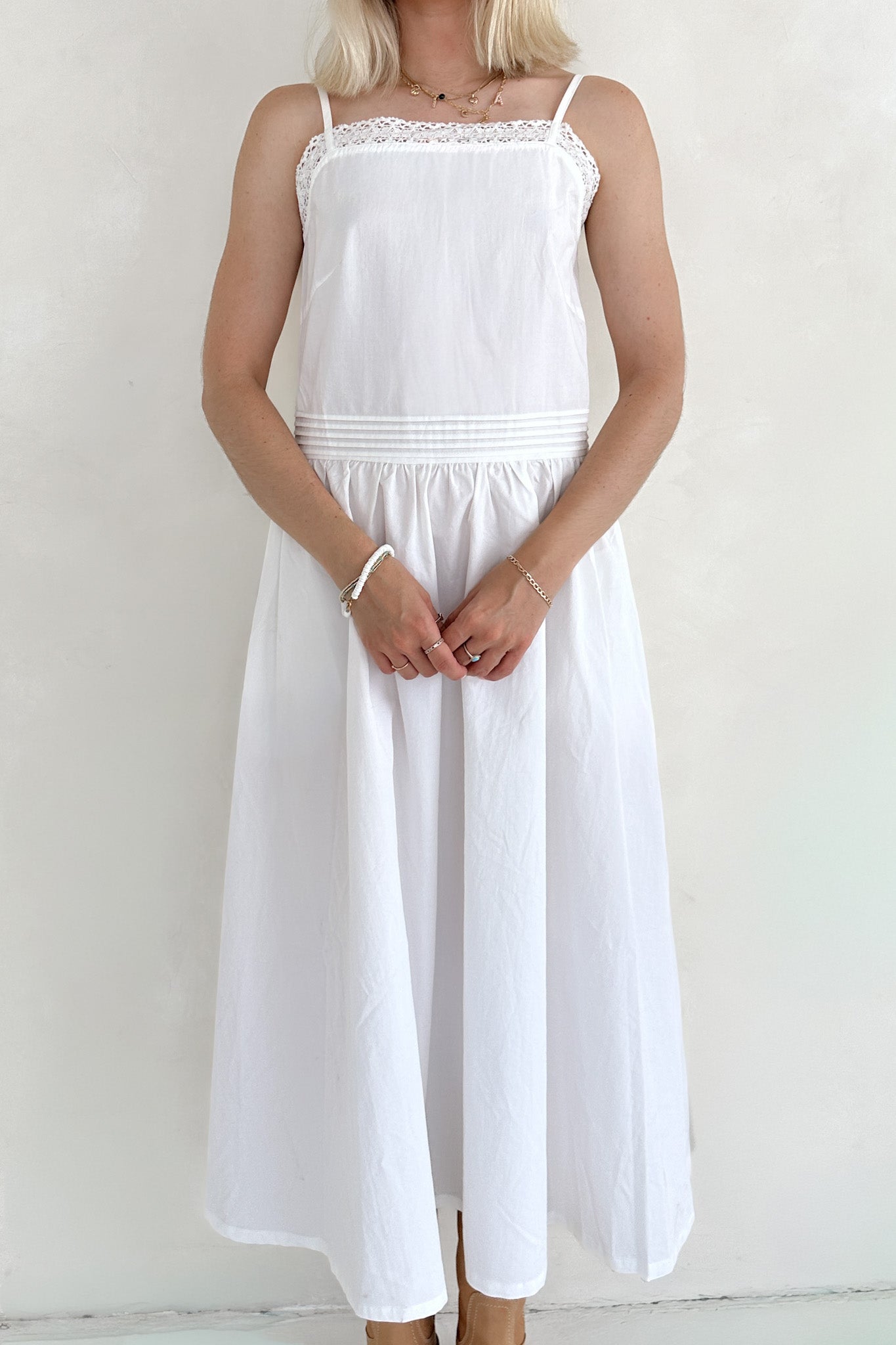 Person wearing a white dress against a plain background