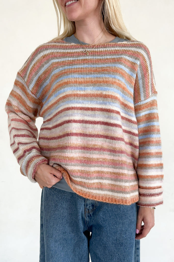 Person wearing a striped sweater with a neutral background