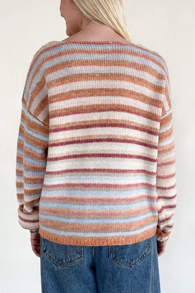 Person wearing a striped sweater with a neutral background