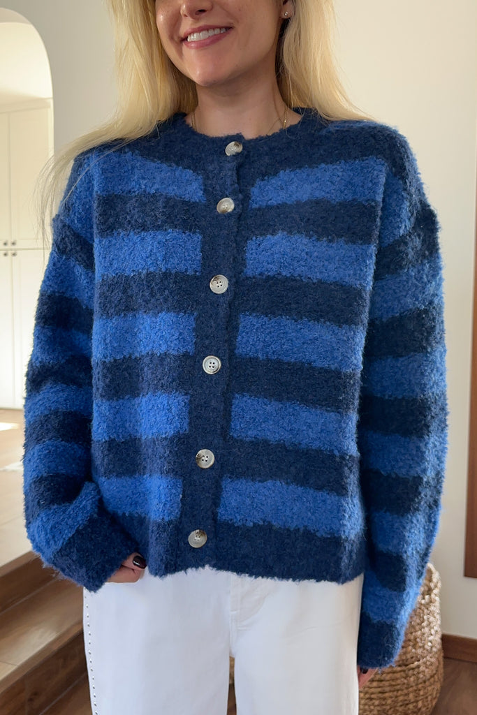 Person wearing a blue striped cardigan indoors