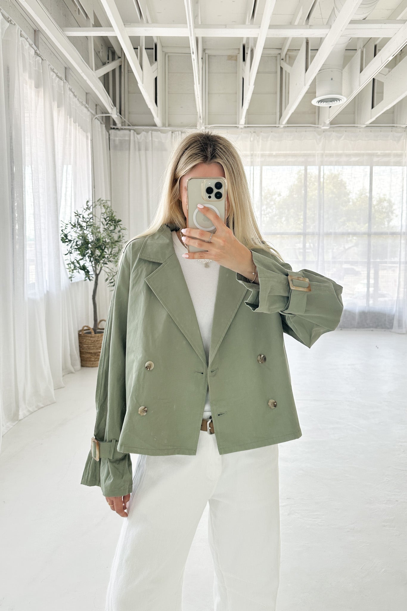 Person wearing a green jacket in a bright, minimalistic room.