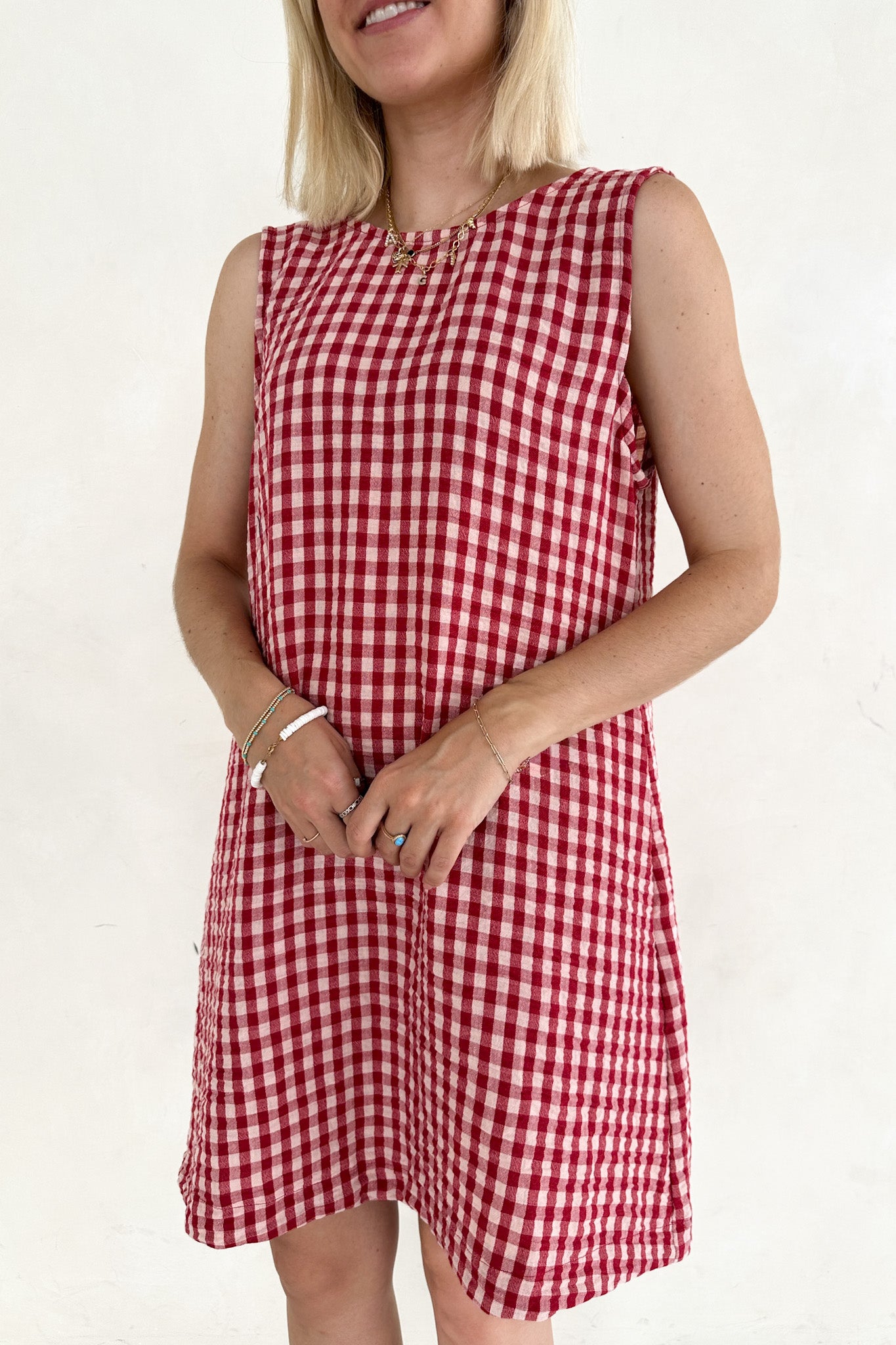 Woman wearing a red and white checkered dress on a plain background