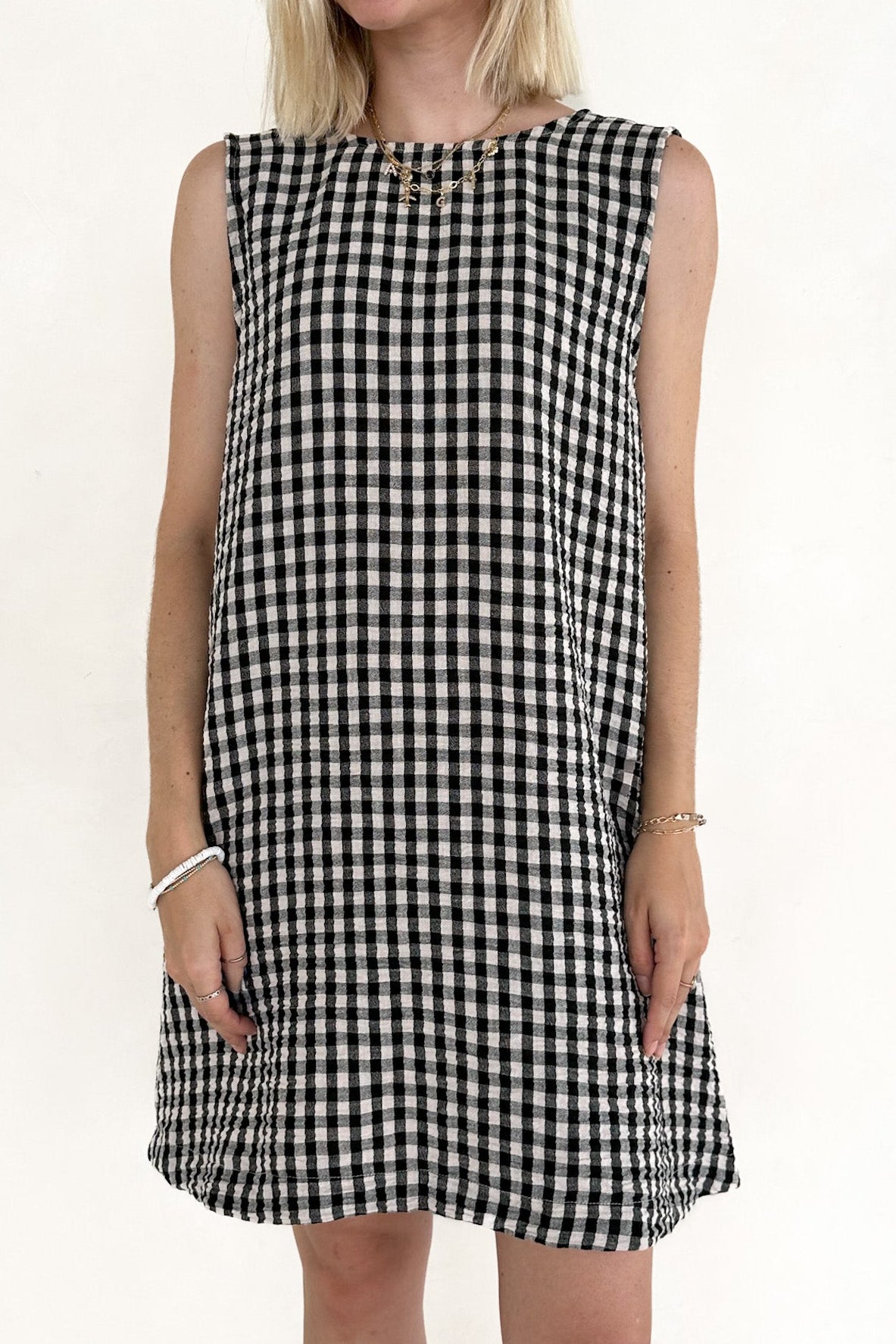 Woman wearing a black and white checkered dress on a plain background
