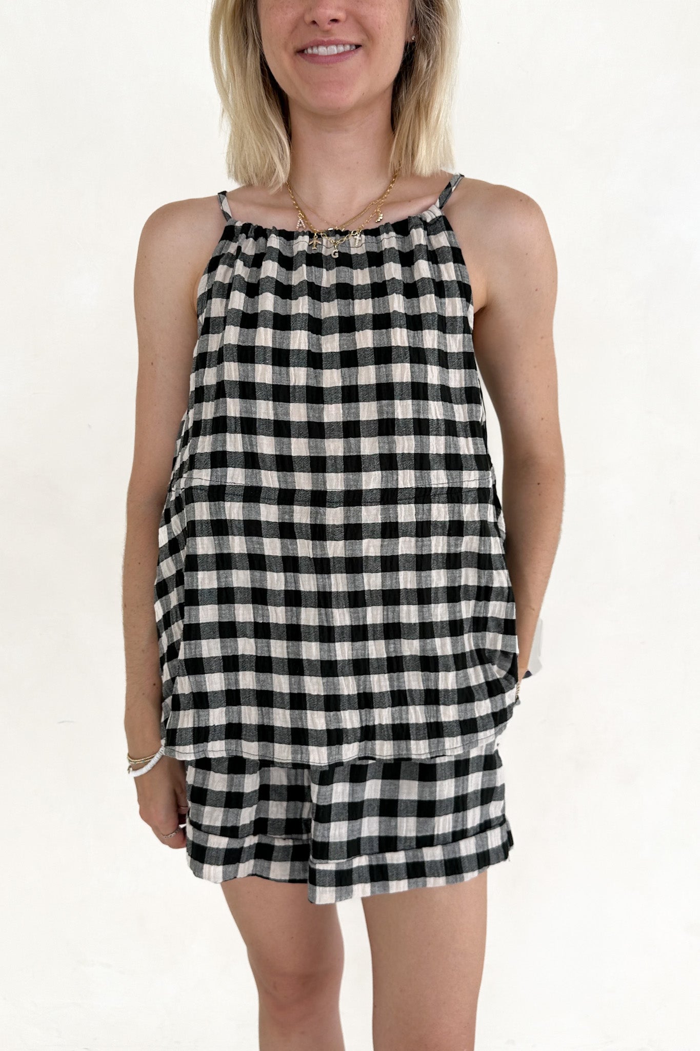 Woman wearing a black and white checkered dress on a plain background
