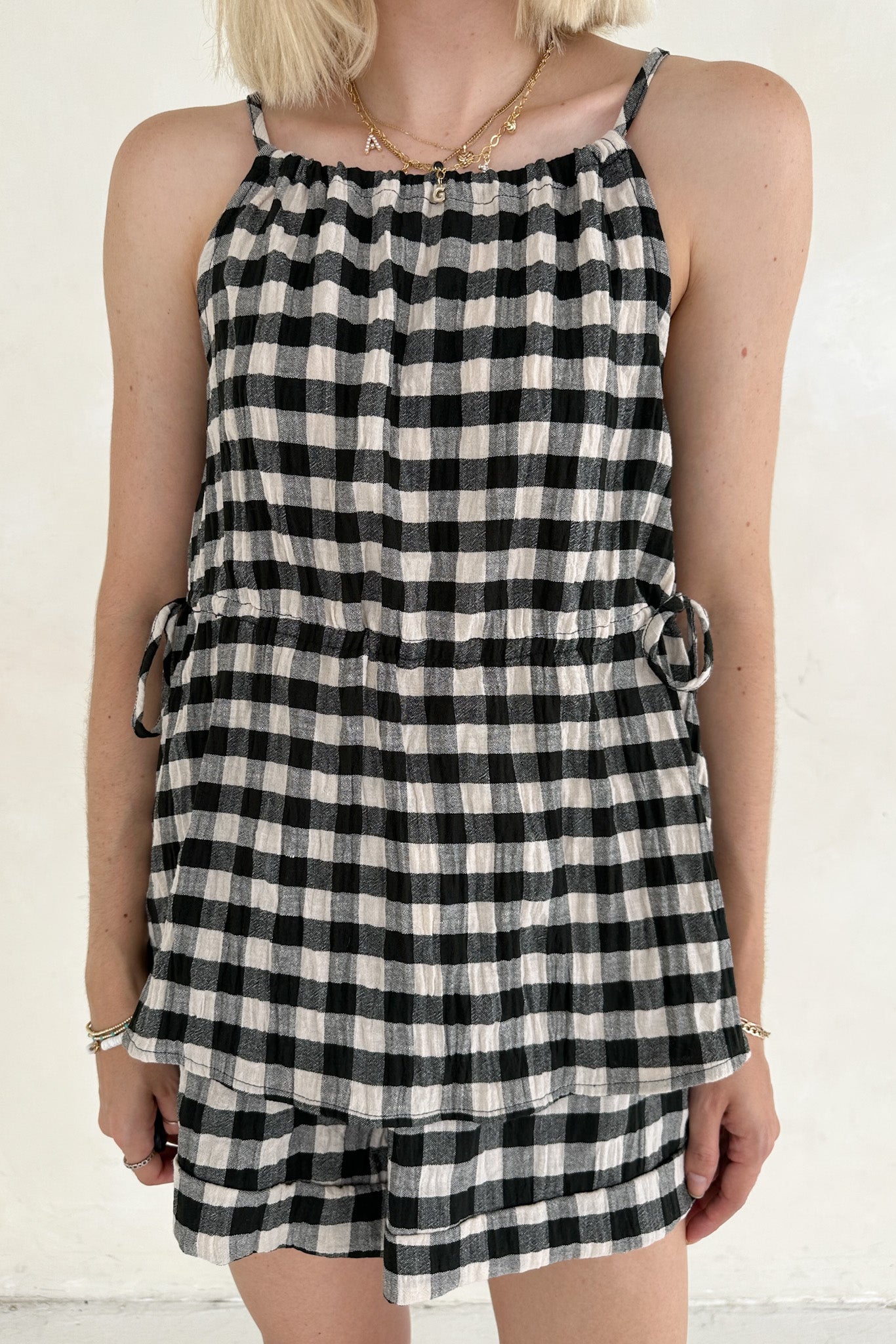 Person wearing a black and white checkered dress against a white background