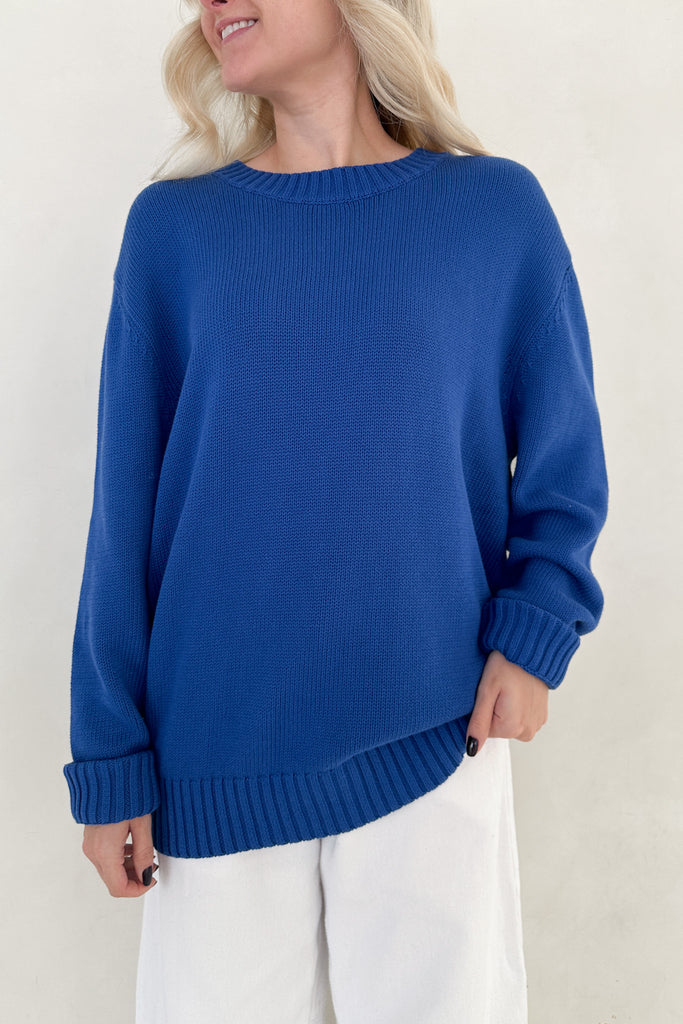 Person wearing a blue sweater against a white background