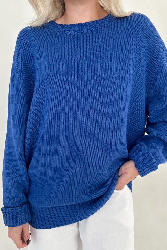 Person wearing a blue sweater against a white background
