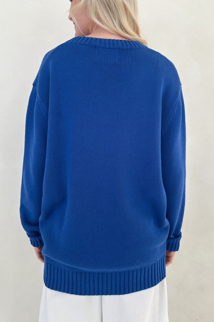 Person wearing a blue sweater against a white background