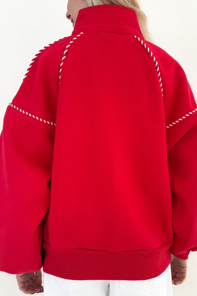 Red jacket with white stitching on a plain background
