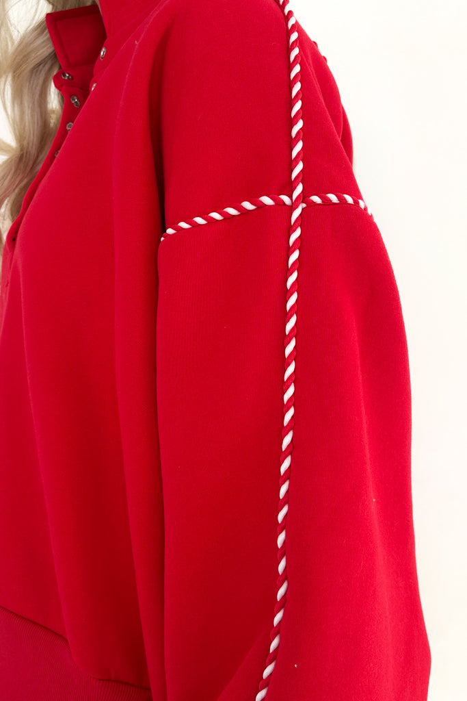 Red garment with white stitching detail on a white background