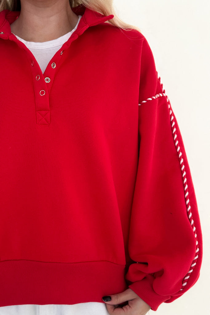 Red sweater with white trim on a white background