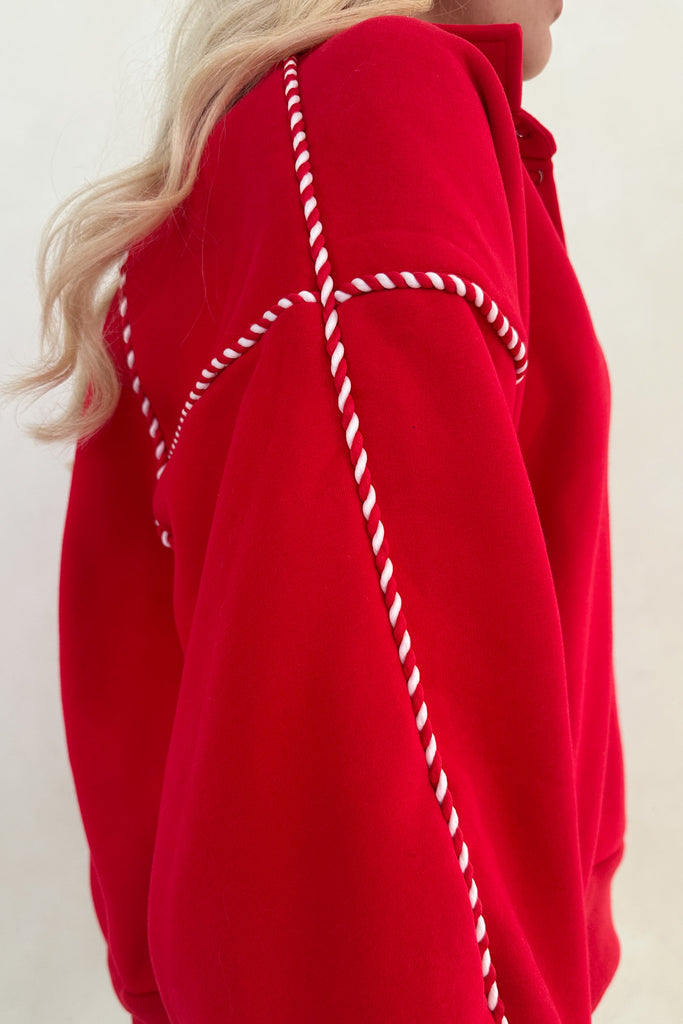 Red garment with white stitching detail on a plain background