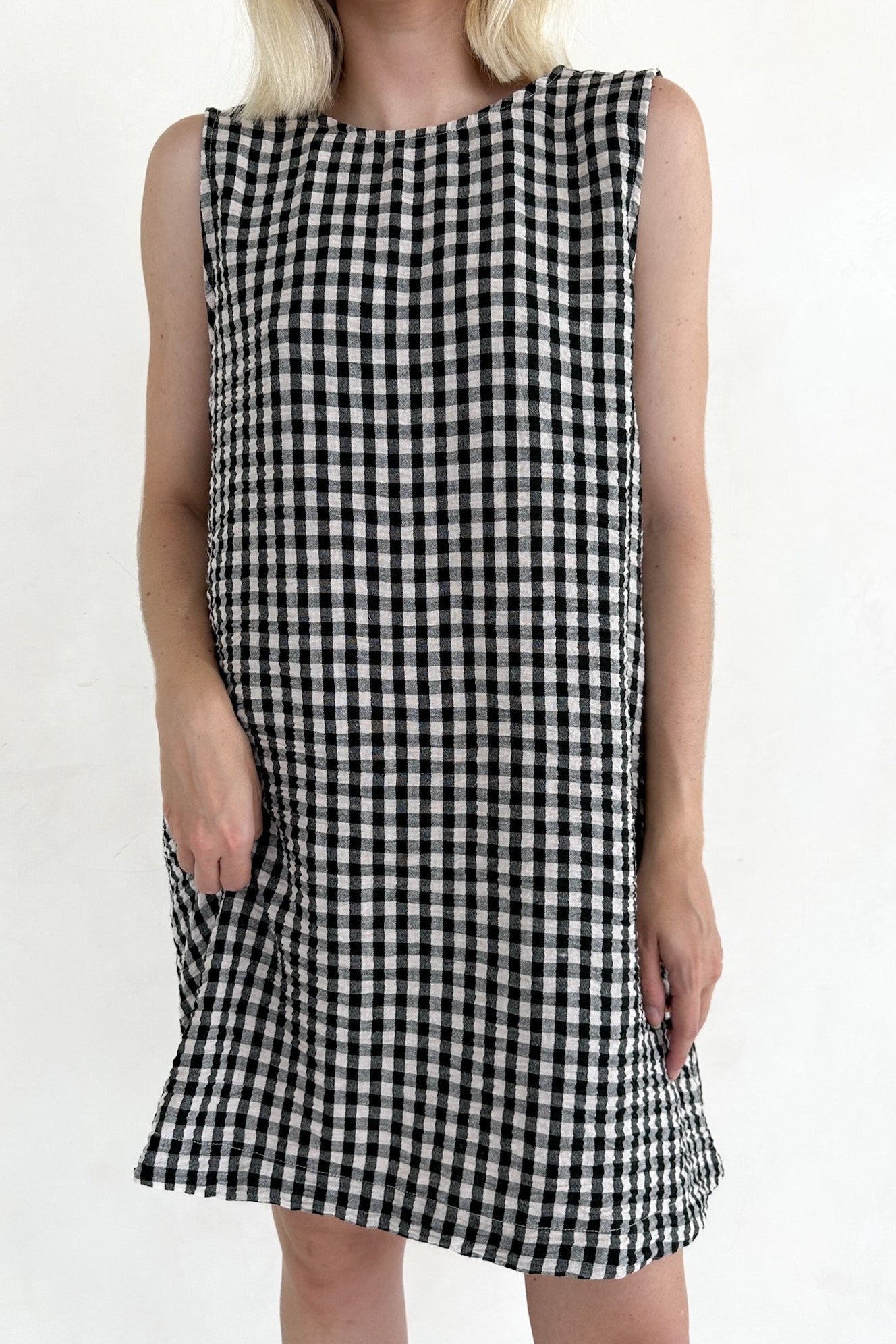 Black and white checkered dress worn by a person on a plain background