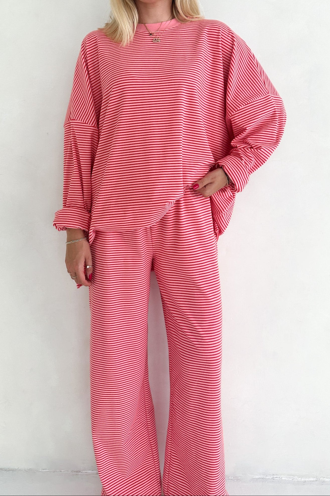 Person wearing a pink striped outfit against a white background