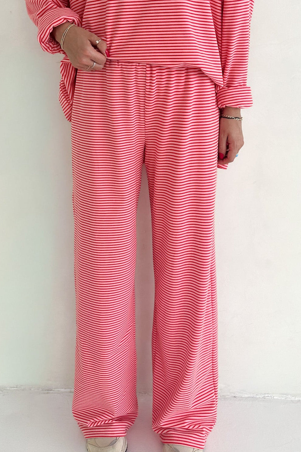 Person wearing a pink striped outfit on a white background