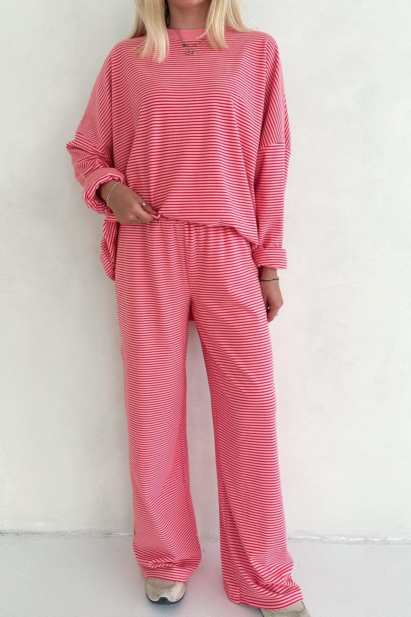 Person wearing a pink striped outfit against a white background