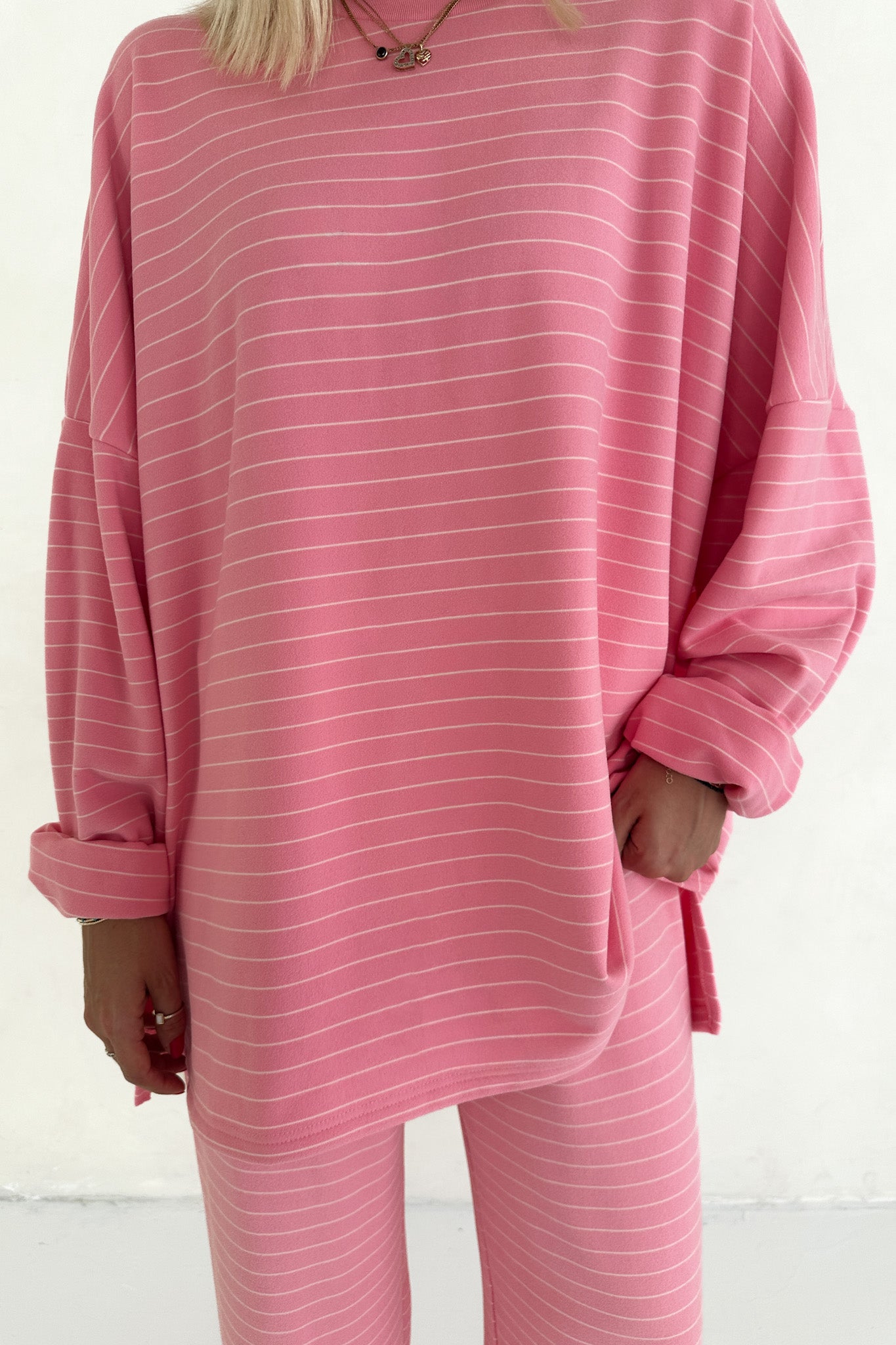 Person wearing a pink striped outfit on a white background