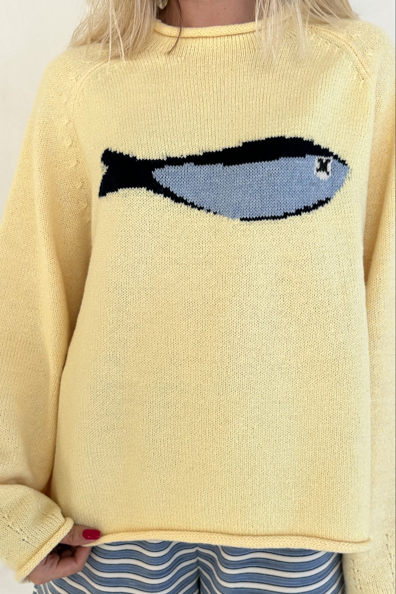 Yellow sweater with a fish design worn by a person