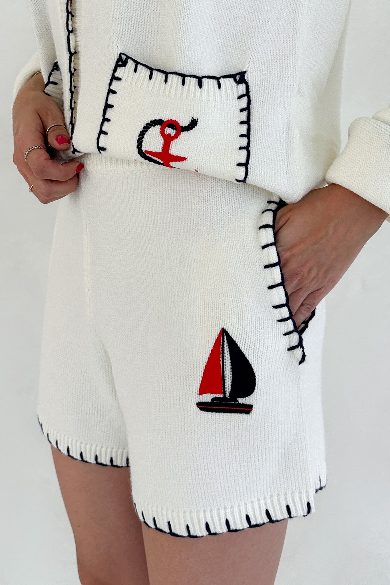 White knitted shorts with sailboat and anchor designs on a plain background